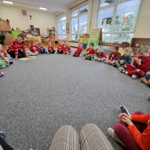 Dzieci wspólnie przekazują sobie jabłko