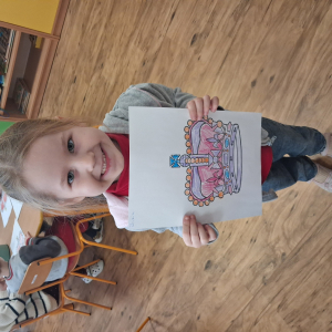 Dziewczynka trzyma pokolorowaną koronę