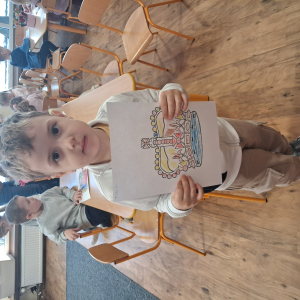 Chłopiec trzyma pokolorowaną koronę