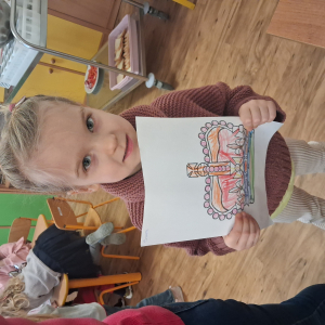 Dziewczynka trzyma pokolorowaną koronę