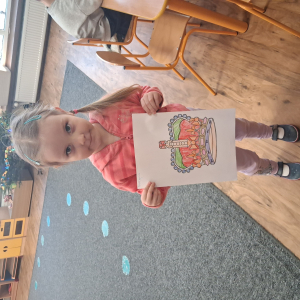 Dziewczynka trzyma pokolorowaną koronę