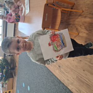 Chłopiec trzyma pokolorowaną koronę