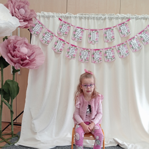 dziewczynka  na tle napisu Dzień Dziewczynek