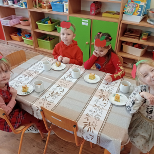 dzieci siedzące przy stolikach podczas poczęstunku