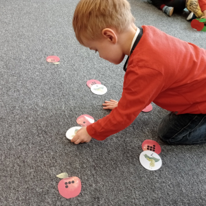 chłopiec przeliczający ile dziurek w jabłku zrobił robaczek