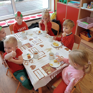 dzieci siedzące przy stolikach podczas poczęstunku