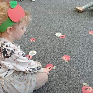 dziewczynka przeliczająca ile dziurek w jabłku zrobił robaczek