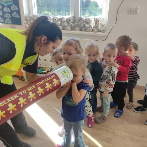 Pani policjantka pokazująca tubę z odblaskami