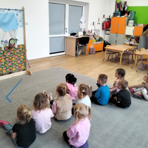 Dzieci oglądające teatrzyk kukiełkowy pod tytułem "Na straganie"