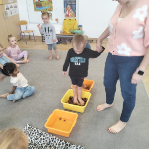 Chłopiec chodzący po ścieżce sensorycznej za kasztanów, wody i liści