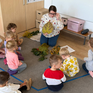 Dzieci podczas zajęć oglądają jesienne liście