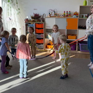 Dzieci stojące w kole trzymają gumę sensoryczną