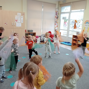 dzieci podczas tańca z kolorowymi chustkami