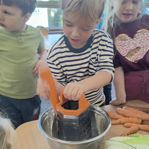 chłopiec podczas tarcia marchewki