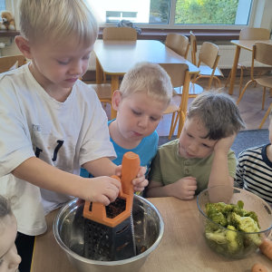 chłopiec podczas tarcia marchewki