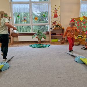 Dzieci w czasie zabawy ruchowej "Zbieranie jabłek do skrzynek"