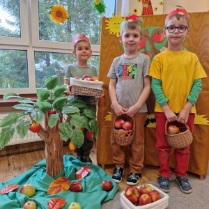   Chłopcy  na tle dekoracji związanej z  "Dniem Jabłka"