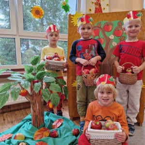 Chłopcy z koszykami i skrzynkami pełnymi jabłek