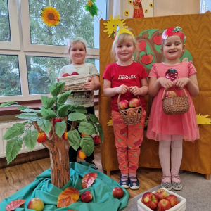 Dziewczynki z koszykami jabłek na tle dekoracji związanej z Dniem Jabłka"