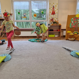 Dzieci w czasie zabawy ruchowej "Zbieranie jabłek do skrzynek"