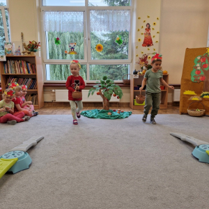 Dzieci w czasie zabawy ruchowej "Zbieranie jabłek do skrzynek"