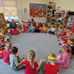 Dzieci śpiewają piosenkę i rytmicznie uderzają dłońmi o uda