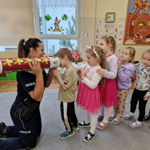 Chłopiec  patrzy  w tubę, aby dostrzec różnice pomiędzy ludzikiem w odblaskach lub bez nich 