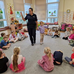 Pani Iza z dziewczynką z grupy pokazuje dzieciom sposób przechodzenia po pasach