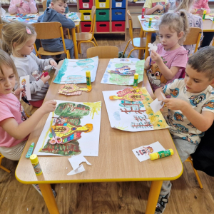 Dzieci wycinają lub naklejają obrazki "Jasia", "Małgosi" lub "chatkę Baby Jagi" na wcześniej namalowany las 