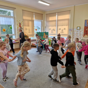 Dzieci w "zaprzęgach" biegną dookoła sali