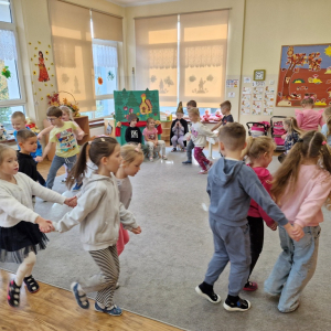 Dzieci w "zaprzęgach" biegną dookoła sali