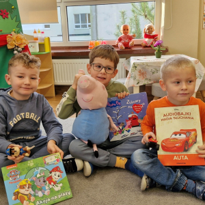 Dzieci prezentują przyniesioną z domu książkę i zabawkę - postać z tej bajki