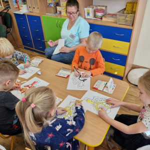 Dzieci kolorują pisakami "chatkę Baby Jagi"