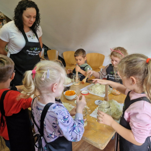 Dzieci ubijają kapustę w słoikach pod okiem Pani Doroty