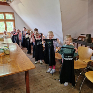 Dzieci trzymają fartuszki, aby Pan Krzysztof sprawnie je zebrał