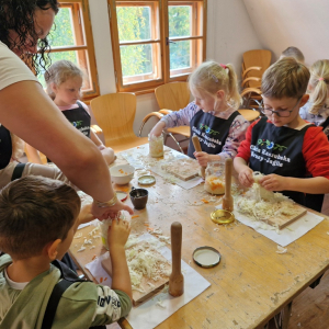 Mama Maurycego pomaga dziecku włożyć kapustę do słoika