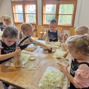 Dzieci ubijają kapustę w słoikach