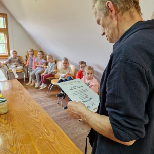 Pan Krzysztof czyta treść  Certyfikatu dla grupy "Skrzaty" za udział w warsztatach "Kapuściana przygoda"