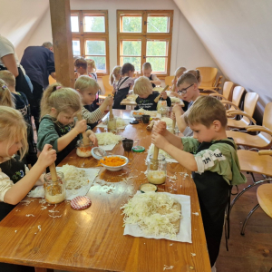 Dzieci ubijają kapustę w słoikach