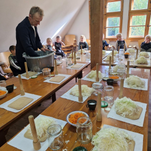 Pan Krzysztof rozkłada kapustę na przygotowanych stanowiskach pracy dla dzieci