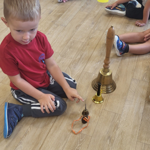 Chłopiec odgadujący, który dzwon wybrzmiał.