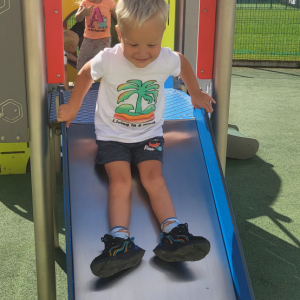 Chłopiec zjeżdża na zjężdżalni.