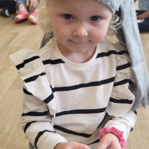 Dziewczynka próbuje odgadnąć co wylosowała przy pomocy zmysłu dotyku.