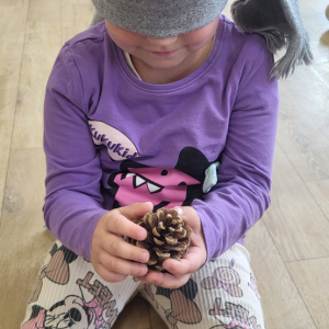 Dziewczynka próbuje odgadnąć co wylosowała przy pomocy zmysłu dotyku.