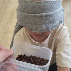 Dziewczynka próbuje odgadnąć co wylosowała przy pomocy zmysłu węchu..