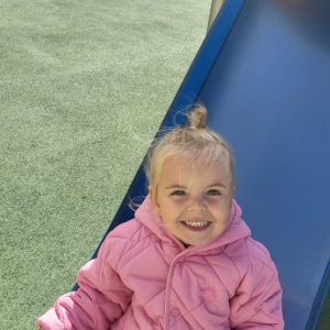 Dziewczynka zjeżdża na zjeżdżalni.