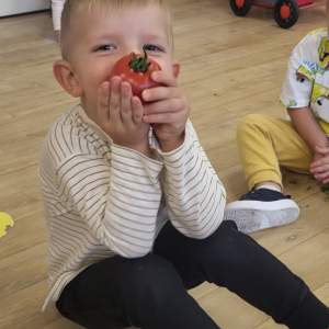 Chłopiec trzymający pomidora.