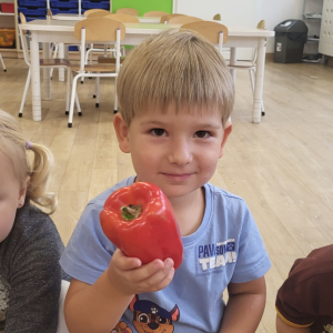Chłopiec trzymający paprykę.
