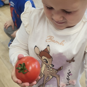 Dziewczynka próbuje odgadnąć jakie warzywo wylosowała.