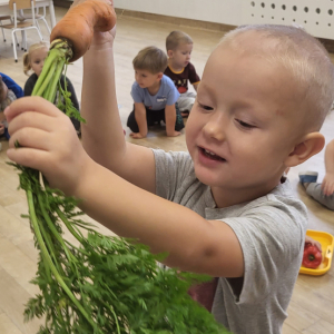Chłopiec trzymający marchewkę.